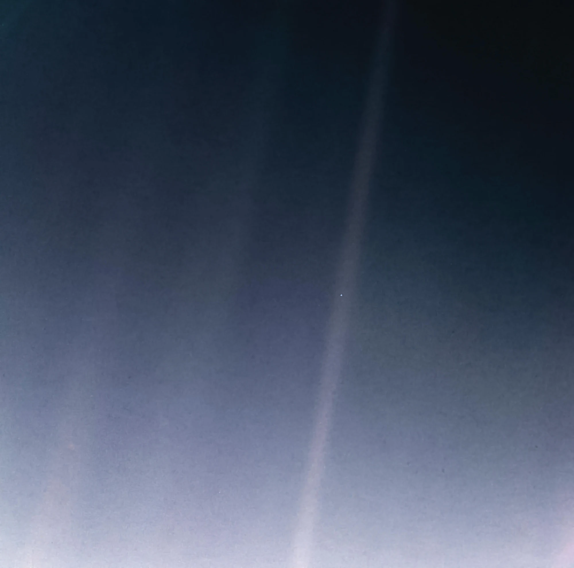 La Tierra aparece como un diminuto punto azul dentro de un haz de luz en la oscuridad del espacio.